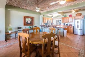 a kitchen and dining room with a wooden table and chairs at Spacious Beachfront Condo Las Palmas II 11A in Puerto Peñasco