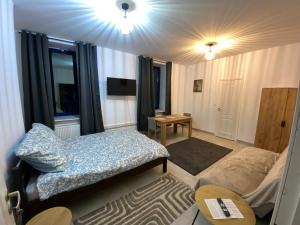 a small room with a bed and a table at Mossmarken Stay in Warsaw