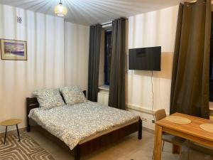 a bedroom with a bed and a tv on the wall at Mossmarken Stay in Warsaw