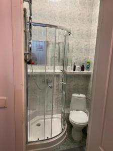 a bathroom with a shower and a toilet at Mossmarken Stay in Warsaw