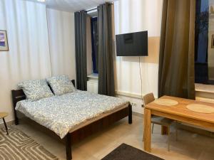 a bedroom with a bed and a tv and a table at Mossmarken Stay in Warsaw +7 photos