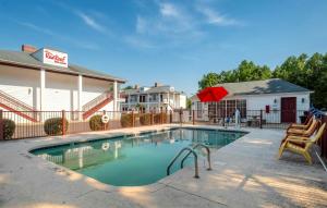 a swimming pool in front of a building at Red Roof Inn & Suites Wilson in Wilson