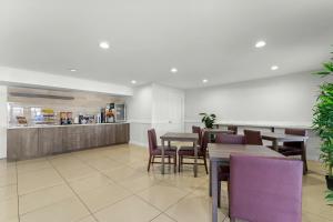 a dining room with tables and purple chairs at Red Roof Inn & Suites Wilson in Wilson