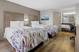 a hotel room with two beds and a desk at Red Roof Inn & Suites Wilson in Wilson +35 photos