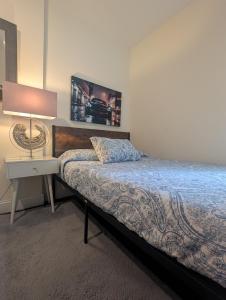 a bedroom with a bed and a nightstand with a lamp at MANHATTAN ROSE Homestay in New York