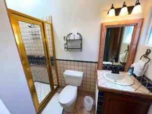a bathroom with a toilet and a sink and a mirror at Comfortable Beachfront Condo Las Palmas II 11 B in Puerto Peñasco