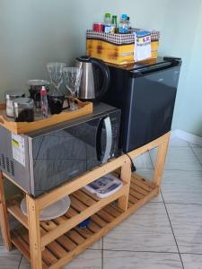 a microwave oven sitting on a wooden stand in a kitchen at Aconchego do Lar Hostel in Palhoça