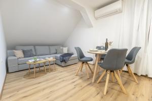 a living room with a couch and a table and chairs at Apartman ''Kod bake'' Delnice biker-friendly in Delnice