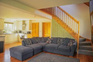 a living room with a couch and a staircase at Maple in Knighton