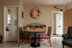 a dining room table with chairs and a mirror on the wall at Sandpiper Alnmouth in Alnmouth