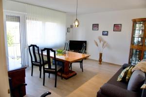 a living room with a wooden table and chairs at Ruhiges Apartment am Stadtrand in Kevelaer