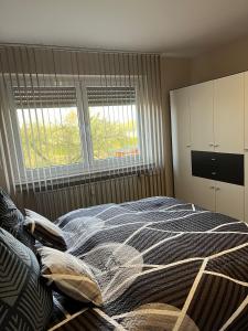 a bedroom with a large bed and two windows at Ruhiges Apartment am Stadtrand in Kevelaer
