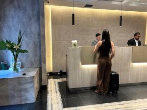 a woman waiting at a counter in a bathroom at 1253 Recoleta Small Hotel in Buenos Aires