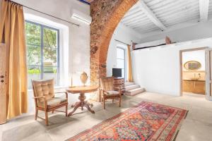 a living room with a table and chairs and a brick wall at Garibaldi Art Apartment in Piombino