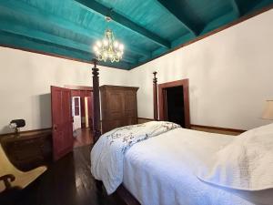 a bedroom with a white bed and a chandelier at The Courtableau Cottage in Washington