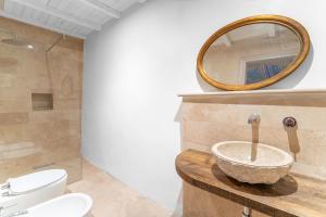 a bathroom with a sink and a toilet and a mirror at Garibaldi Art Apartment in Piombino +22 photos