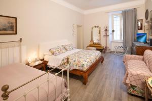 a bedroom with two beds and a couch at La Dimora di B.Cairoli in Ovada