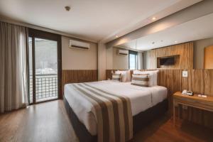 a hotel room with a large bed and a window at Pestana Rio Atlantica in Rio de Janeiro
