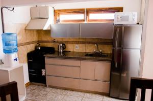 a kitchen with a stainless steel refrigerator and a sink at Departamentos Malargue in Malargüe
