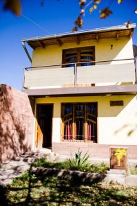 a yellow house with a door and windows at Departamentos Malargue in Malargüe