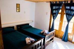two beds in a bedroom with slippers on them at Departamentos Malargue in Malargüe