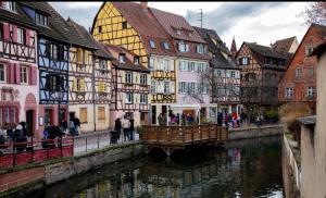 a group of buildings next to a river in a city at Le Charme de Colmar B&B in Colmar