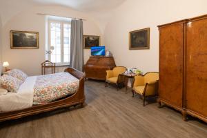 a bedroom with a bed and a dresser and a desk at La Dimora di B.Cairoli in Ovada