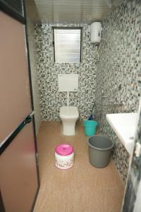 a small bathroom with a toilet and a sink at Swayam Beach Nivas in Srīvardhan
