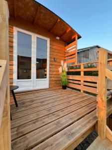 a cabin with a wooden deck with a window at La Roulotte des Gaillots in Moiremont