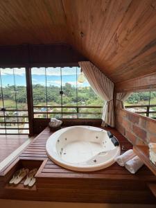 a large bath tub in a room with windows at Chalé Vicenza in Marques de Sousa +11 photos