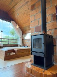 a living room with a fireplace and a tv at Chalé Vicenza in Marques de Sousa