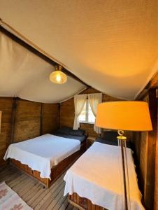 a bedroom with two beds and a lamp at Adrasan Camping in Kumluca