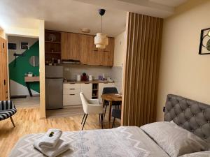 a bedroom with a bed and a table and a kitchen at PRESTIGE studio Krusevac in Kruševac