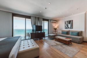 a bedroom with a bed and a couch and a television at Pestana Rio Atlantica in Rio de Janeiro +27 photos