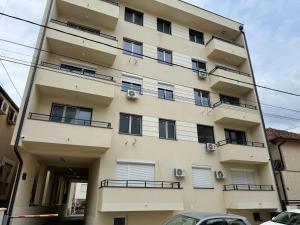 a building with balconies and cars parked in front of it at PRESTIGE studio Krusevac in Kruševac