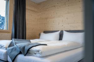 a bedroom with a bed with white sheets and pillows at Residenza Pazzola in Disentis