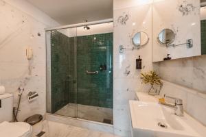 a bathroom with a shower and a sink and a toilet at Pestana Rio Atlantica in Rio de Janeiro