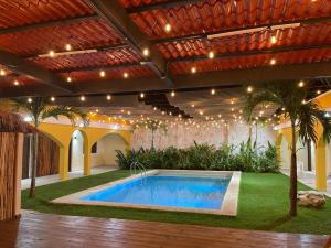 a swimming pool in a backyard with a large building at Hotel Villa Chucum in Valladolid