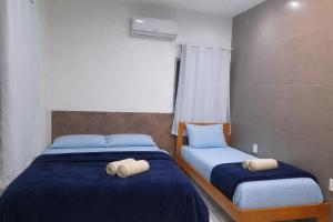 two beds in a room with towels on them at Aguas de Alter in Santarém