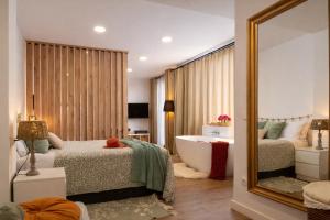 a bedroom with two beds and a mirror and a tub at Private Loft Sant Celoni, Montseny, Barcelona in Sant Celoni +8 photos