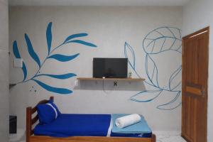 a room with a blue couch and a tv on a wall at Aguas de Alter in Santarém