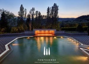 a swimming pool with lights in the water at Civico68 in Cetona