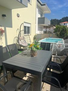 a table and chairs with a plant on a patio at Grace House Quarto single privado in Belinho