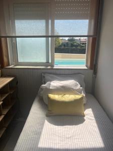 two beds in a room with a window at Grace House Quarto single privado in Belinho +8 photos