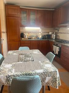a kitchen with a table and chairs with a tablecloth on it at Grace House Quarto single privado in Belinho