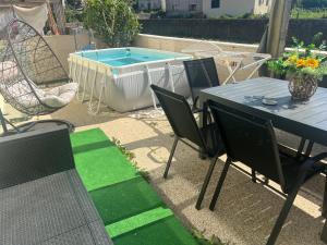 a patio with a table and chairs and a swimming pool at Grace House Quarto single privado in Belinho