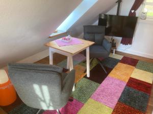 a living room with a table and a chair and a television at gemütliches Gästezimmer in Ostseenähe in Stubbendorf