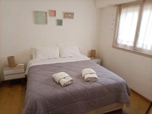 a bedroom with a bed with towels on it at Casa Nanet Hotel in Mar del Plata