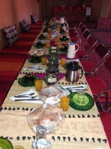 a long table with plates of food on it at Hamada Kem-Kem Tafraoute in Tafraoute Sidi Ali