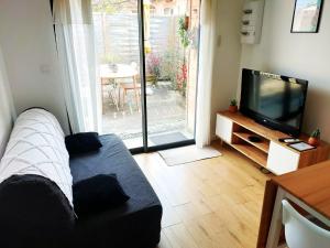 a living room with a couch and a television at L'instant voyageur in Virsac